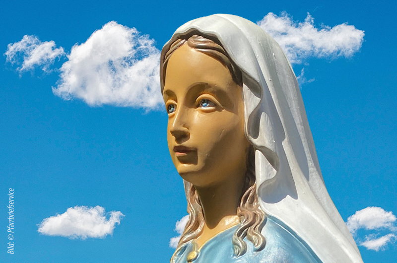 Statue (Kopf) von Jungfrau Maria vor einem blauen Himmel mit Wolken